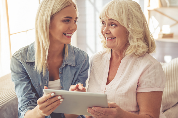 Two generations smiling at each other with iPad