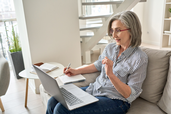 Older woman on computer taking notes